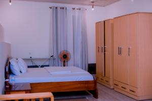 1 dormitorio con 1 cama y armario grande en Green V Apartments, en Kigali