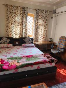 1 dormitorio con 1 cama y una ventana con cortinas en Bashaw Residency, Top Rated Family Guest House Near Srinagar Airport, en Srinagar
