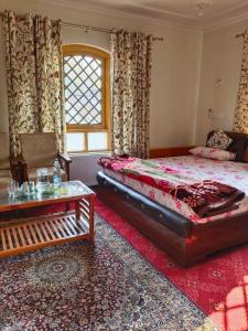 a bedroom with a bed and a table at Bashaw Residency, Top Rated Family Guest House Near Srinagar Airport in Srinagar