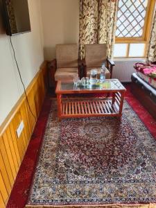a living room with a coffee table and a couch at Bashaw Residency, Top Rated Family Guest House Near Srinagar Airport in Srinagar