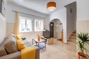 a living room with a couch and a tv at City center, private parking, AC, 6ppl. in Olhão