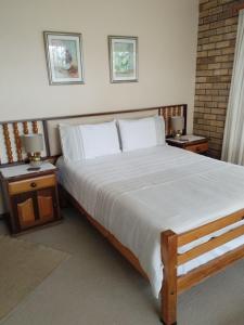 a bedroom with a large bed with two night stands at Remini in Jeffreys Bay