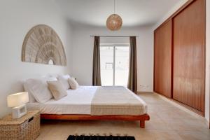 a bedroom with a bed and a large window at City center, private parking, AC, 6ppl. in Olhão