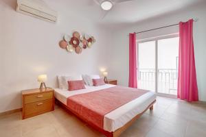 a bedroom with a bed and a large window at City center, private parking, AC, 6ppl. in Olhão