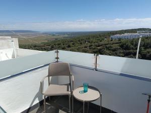 uma cadeira e mesa numa varanda com vista em Mar a la Vista em Vejer de la Frontera