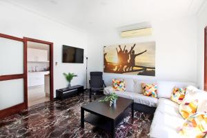 a living room with a white couch and a table at Villa Marbella by Slow Villas in Playa de Palma +33 photos