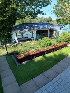 einen Garten mit einer Holzbank und einem Pavillon in der Unterkunft Vikendica Drinski mir in Loznica
