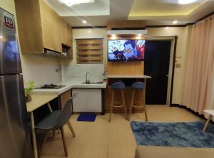 a small kitchen with a sink and a tv in it at Casita de Reina Staycation House - A cozy 1-Bedroom condo-style house in Daraga