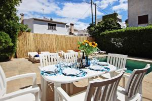 a white table with white chairs and flowers on a patio at Villa Marbella by Slow Villas in El Arenal