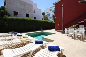 a group of chairs and a swimming pool with a table at Villa Marbella by Slow Villas in El Arenal