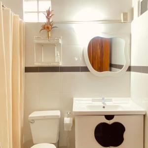 a bathroom with a white toilet and a sink at Abihon HoferHaus Mactan Guesthouse in Lapu Lapu City