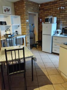 a kitchen with a table and a white refrigerator at Remini in Jeffreys Bay