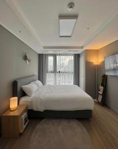 una camera da letto con un letto grande e una finestra di INN-The City MyeongDong a Seul