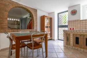 a kitchen with a table and chairs and a fireplace at TonyHouse in Casal Palocco