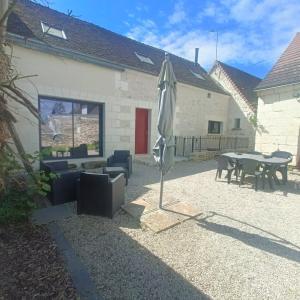 eine Terrasse mit einem Tisch und einem Sonnenschirm in der Unterkunft Belle Maison tourangelle pour 6 personnes in Chambourg-sur-Indre