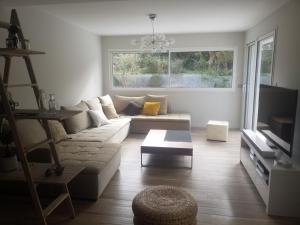 a living room with a couch and a table at Les Echappees belles - La Villa in Tarnos
