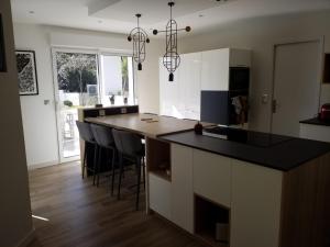 a kitchen with a island with a black counter top at Les Echappees belles - La Villa in Tarnos