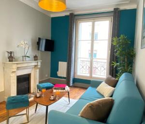 uma sala de estar com um sofá azul e uma lareira em 1609 - Eiffel Tower Haven Olympic Games 2024 em Paris