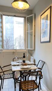 uma sala de jantar com uma mesa e cadeiras e uma janela em 1609 - Eiffel Tower Haven Olympic Games 2024 em Paris