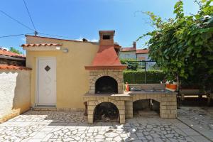 einen Steinofen in einem Hof mit einem Gebäude in der Unterkunft Ferienwohnung für 3 Personen ca 32 qm in Valbandon, Istrien Istrische Riviera in Valbandon