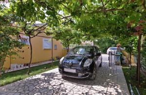 ein schwarzes Auto auf einem Bürgersteig neben einem Haus geparkt in der Unterkunft Ferienwohnung für 3 Personen ca 32 qm in Valbandon, Istrien Istrische Riviera in Valbandon