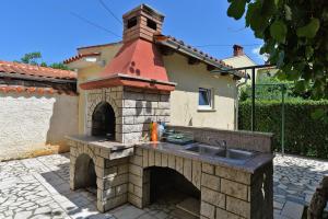 eine Außenküche mit einer Spüle und einem Backsteinofen in der Unterkunft Ferienwohnung für 3 Personen ca 32 qm in Valbandon, Istrien Istrische Riviera in Valbandon