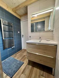 ein Bad mit einem Waschbecken und einem Spiegel in der Unterkunft Chalet Entre Lac et Forêt 4* vue panoramique lac in Gérardmer