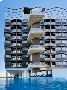a large apartment building with a pool in front of it at WV 7 Serene Haven in Iloilo City +10 photos