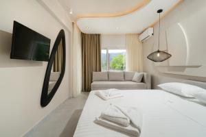 a bedroom with a white bed and a couch at Port Oasis in Limenas