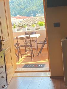 uma porta aberta para uma varanda com uma mesa e cadeiras em Vila Haznedari em Berati