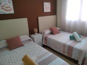 a bedroom with two beds and a window at Apartamento céntrico cerca de la playa in Águilas
