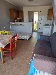 a living room with a couch and a table at A Santy's House 1piano no lift no shuttle solo parcheggio in strada 5 minuti da fermata bus per da fiera di roma nessun pasto no meal, air condiz ed extra bed FOR A FEE A PAGAMENTO in Fiumicino