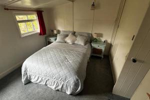 um quarto com uma cama com um edredão branco e uma janela em Sandy Creek em Humberston