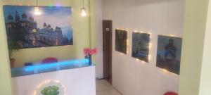 una habitación con tres cuadros en la pared y un jarrón con flores en ADH Amilia Residency en Mysore