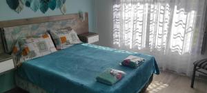 um quarto com uma cama azul e 2 almofadas em Nuestro lugar Ezeiza 6 Tranfer incluido em Ezeiza