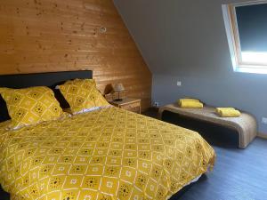 1 dormitorio con 1 cama con edredón amarillo en TY NICO, en Trébeurden