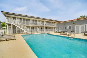 a swimming pool in front of a building with a hotel at Airy Biloxi Condo with Patio Walk to Beach! in Biloxi