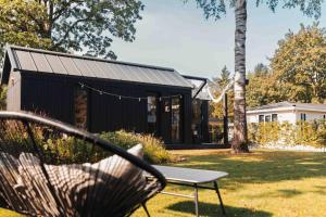 伊皮Fika Tiny House的院子里的长椅，院子里有一栋黑色的房子