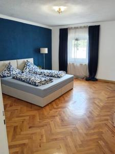a bedroom with a bed with blue walls and a wooden floor at Ferienwohnung Allgäu 3 in Memmingen