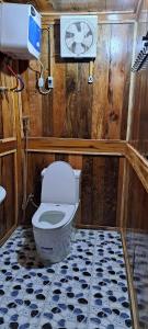 a bathroom with a toilet in a wooden room at Homestay Highland Hmong in Hòa Bình