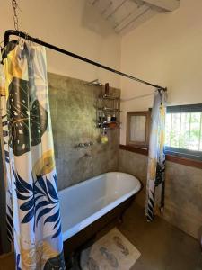 a bathroom with a tub and a shower curtain at Casa de campo Lago Cardiel in Huerta Grande