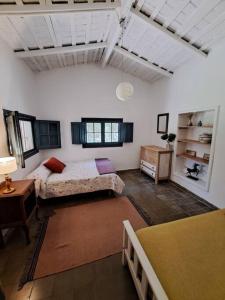 a large room with two beds and a table at Casa de campo Lago Cardiel in Huerta Grande