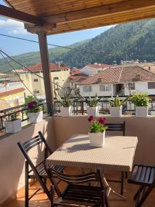 einen Tisch und Stühle auf einem Balkon mit Aussicht in der Unterkunft Vila Haznedari in Berat