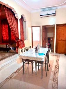 een eetkamer met een tafel en stoelen in een kamer bij Location appartement meublée Taroudant in Taroudant