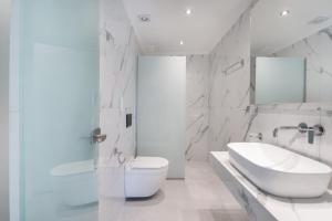 a white bathroom with a toilet and a sink at Port Oasis in Limenas +26 photos
