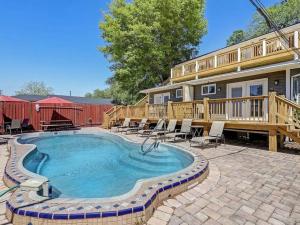 une maison avec une piscine devant une maison dans l'établissement Historic Savannah Gold Private Condo with Pool - 2bed, 1&half bath, Sleeps 6, 1st Floor, 15 Min Walk To Historic Savannah Center And All Attractions, à Savannah