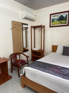 a bedroom with a bed and a chair in it at Sen's Homestay in Ninh Binh