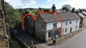 a house with red arrows on the side of it at Beautifully Renovated Old Sweet Shop in Youlgreave