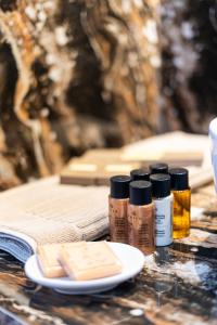 a table with three bottles of paint and a plate of cheese at FLOARA DI MUNTE Forest Luxury Suites in Metsovo