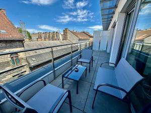 a balcony with blue chairs and a view of a building at Central Apartment Budapest ~ Roof Terrace/AC/Indoor parking in Budapest